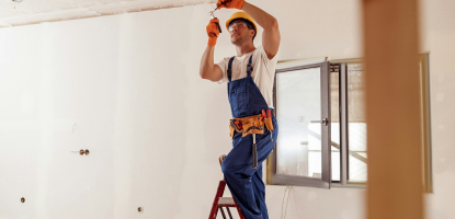 Image - Smiling electrician fixing electric cable on ceiling